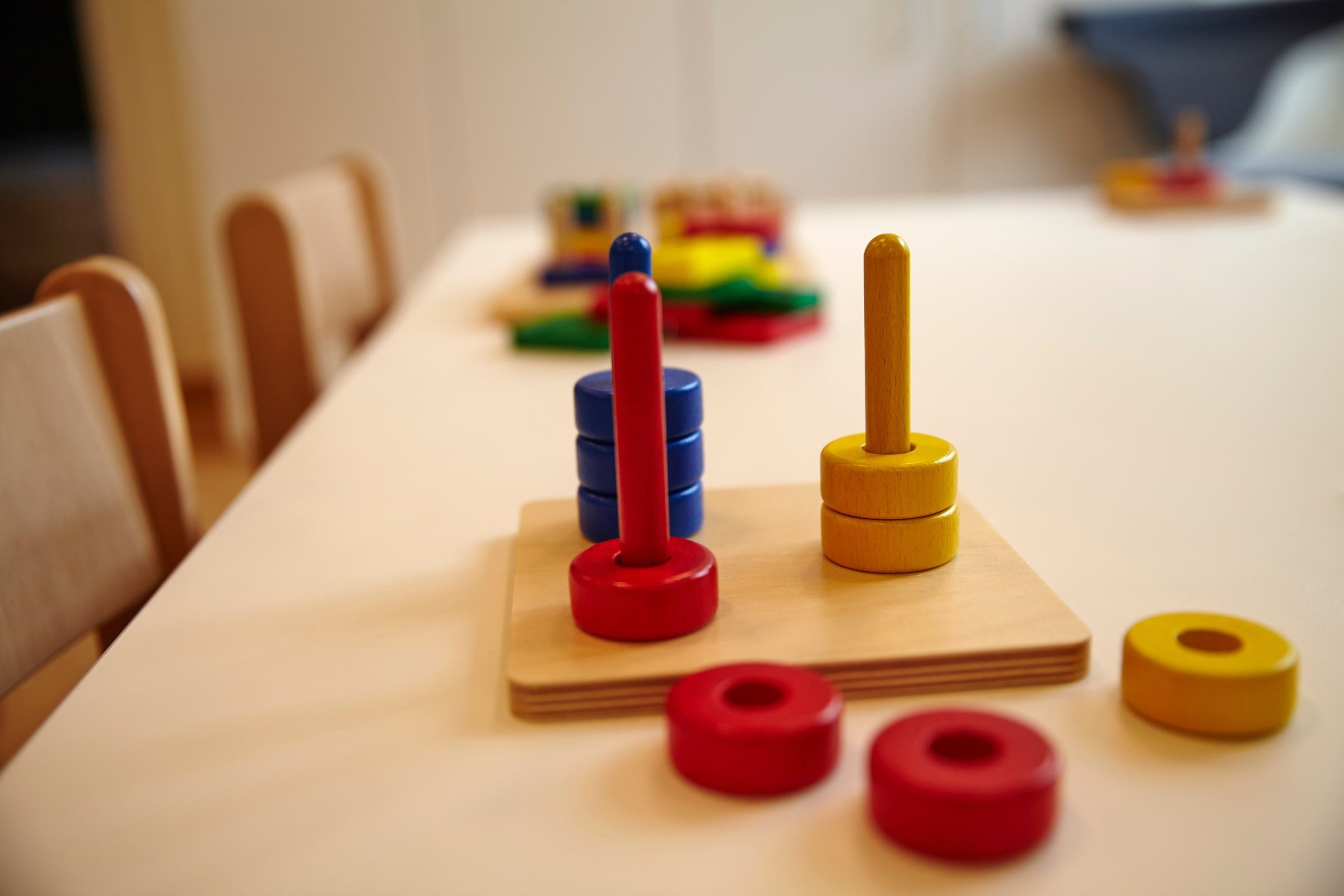 Kindertisch mit hölzernem Lernmaterial und bunten Steckelementen