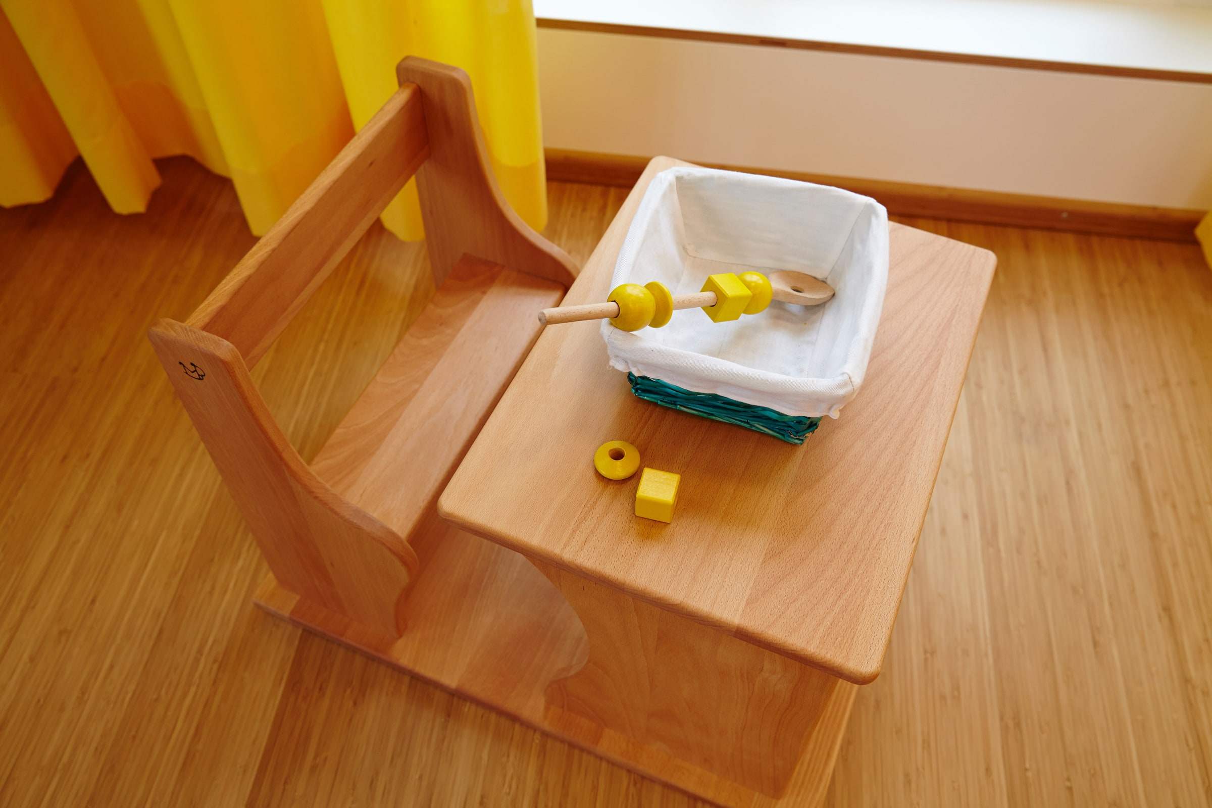 Kleiner Holztisch mit altersgerechtem Lernmaterial und Stühlen