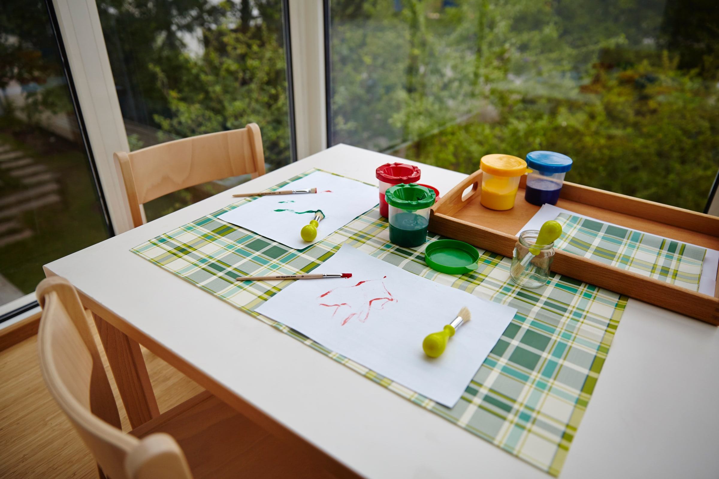 Kindertisch mit Papier, Farben und Bastelmaterialien