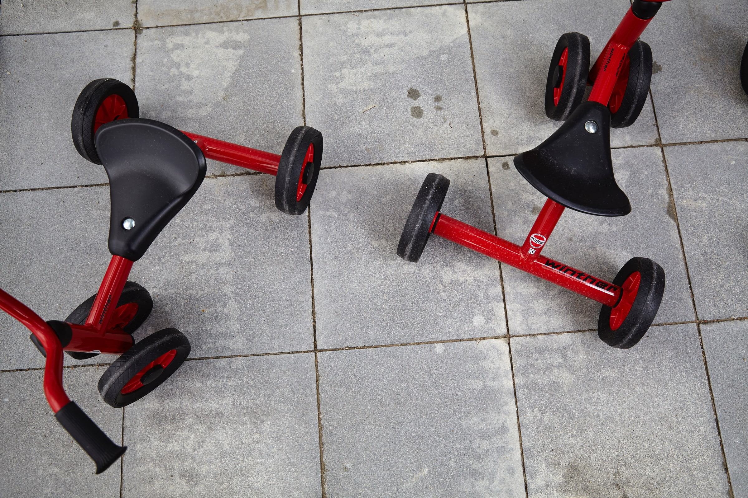 Rote Kinderfahrzeuge auf einem Steinboden