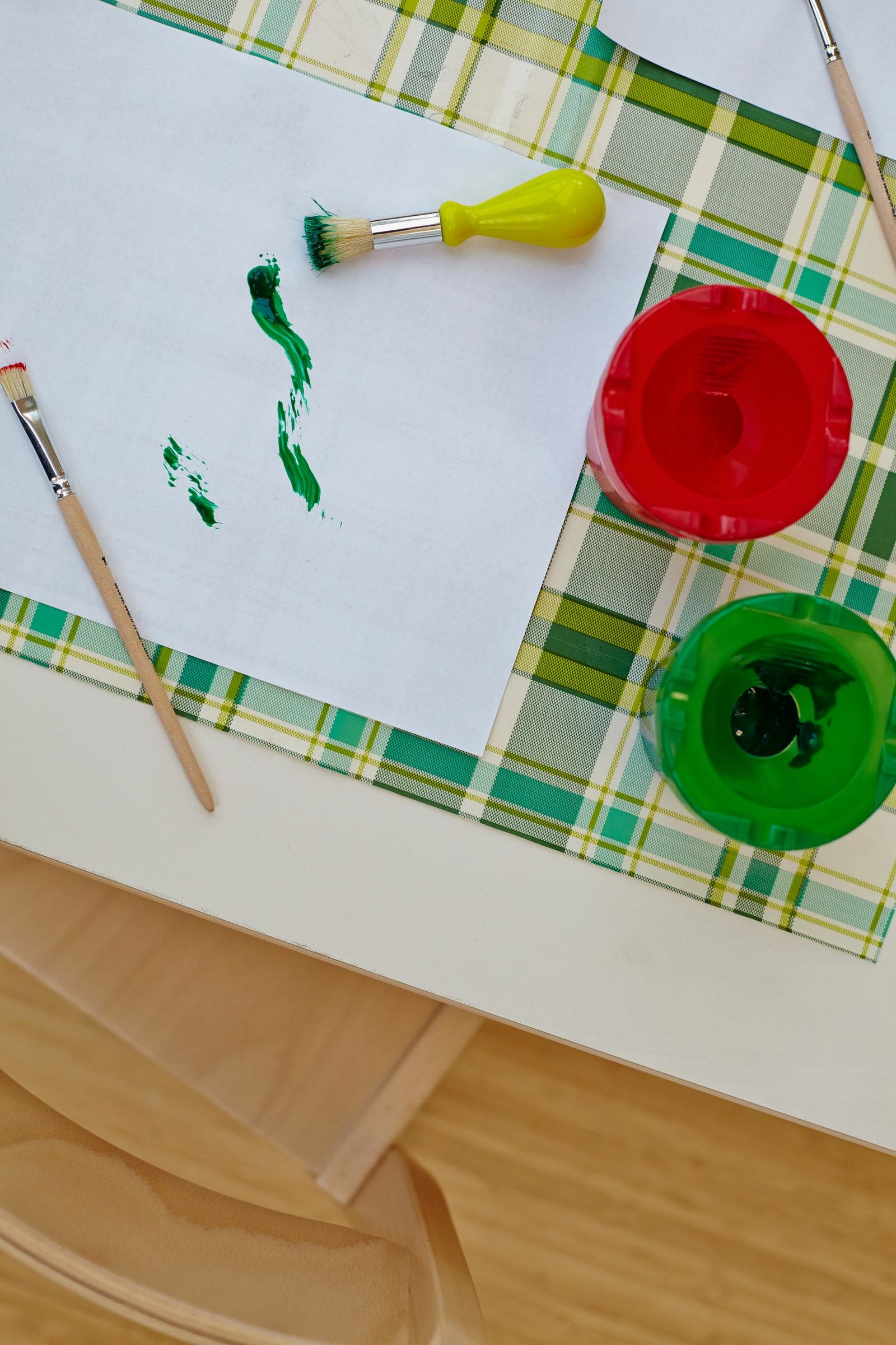 Kinderbild mit Farben und Pinseln auf einem Tisch